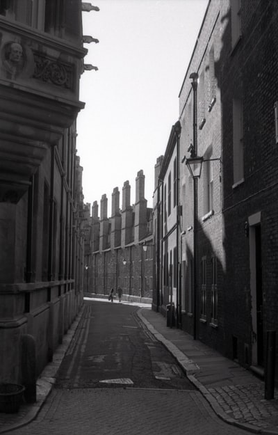 建筑物之间空荡荡的街道的灰度照片